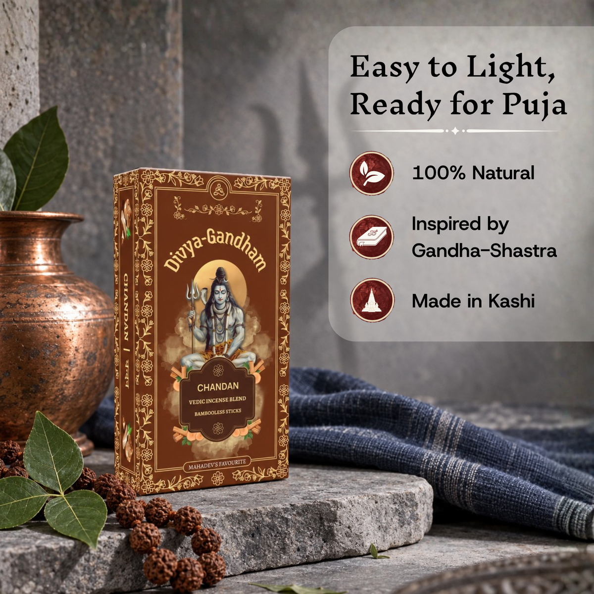 Upright Divyagandham Chandan incense box highlighting it is easy to light, 100% natural, inspired by Gandha-Shastra, and made in Kashi, placed next to a copper kalash and a rudraksha mala.