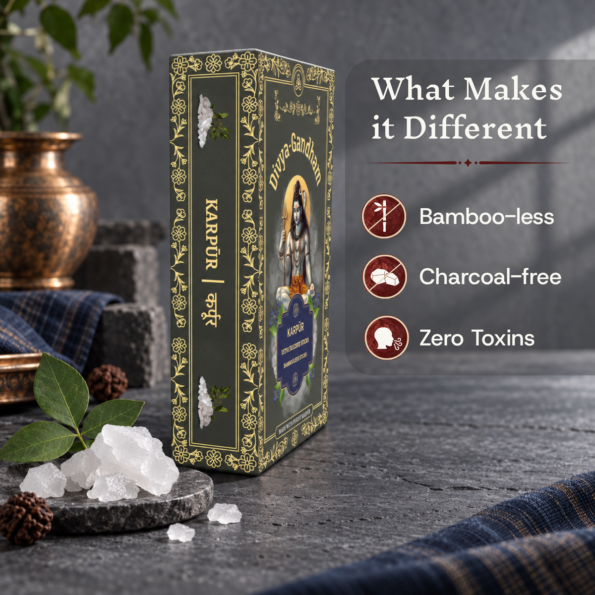 Upright Divyagandham Karpur incense sticks box emphasizing its bamboo-less, charcoal-free, and zero toxins qualities, set next to fresh camphor crystals and a bel leaf on a stone surface.