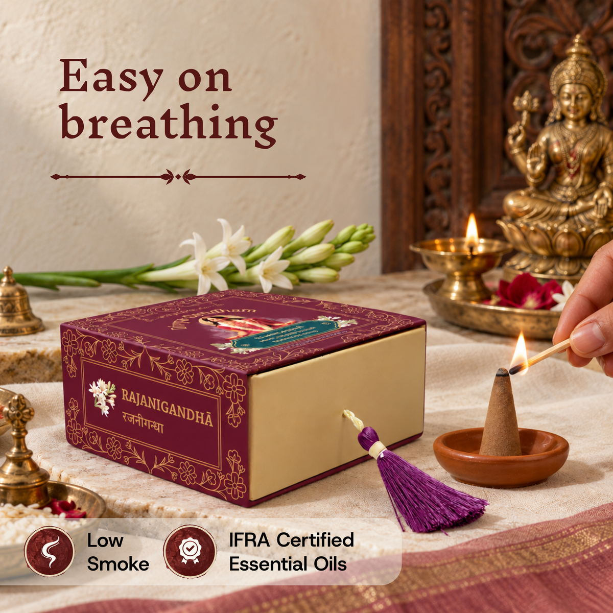 Hand lighting a Divyagandham Rajanigandha incense cone highlighting easy breathing, IFRA certified essential oils, and low smoke, resting near the product box and a Lakshmi idol.