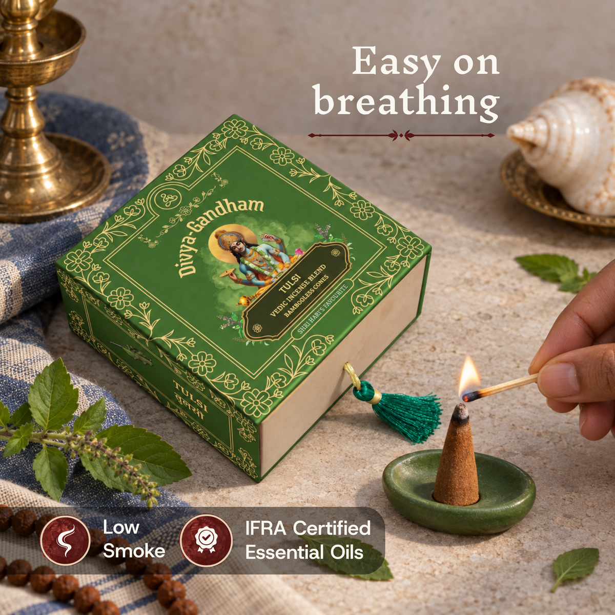 Hand lighting a Divyagandham Tulsi incense cone highlighting easy breathing, IFRA certified essential oils, and low smoke, resting next to the product box and a tulsi mala.