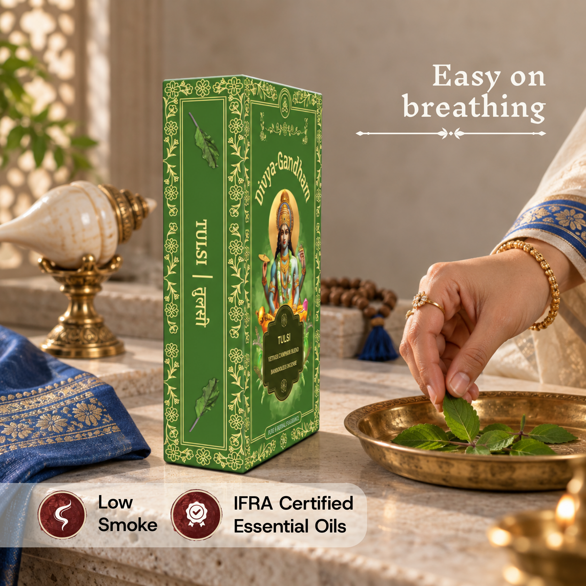 Divyagandham Tulsi incense sticks box highlighting easy breathing, IFRA certified essential oils, and low smoke, as a hand places a tulsi leaf into a brass bowl.